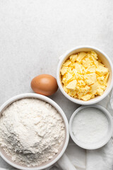 Overhead view of mise en place of ingredients used to make tart shell dough, top view of items used to make pie crust dough