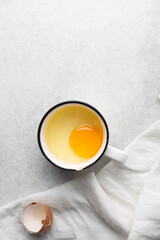 Overhead view of raw egg, whole raw egg in a glass bowl