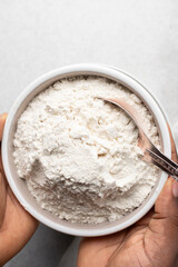 overhead view of All purpose flour in a bowl, top view of baking flour in a ceramic bowl