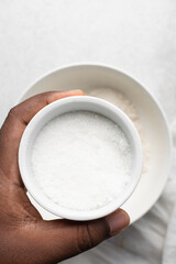 Overhead view of white sugar in a bowl, top view of granulated sugar in a ramekin