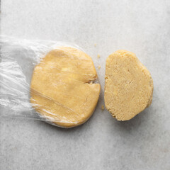 overhead view of tart shell dough on granite countertop, top view of pie shell dough, process of making tart