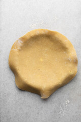 Overhead view of tart crust dough being placed in tart tin, process of making tart shell
