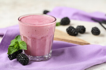 Glass of fresh blackberry smoothie with mint and berries on white background, closeup