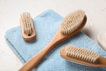 Body massage brushes and towel on white background, closeup