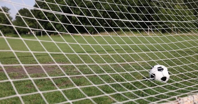 Hitting soccer ball in net outdoors, closeup. Football game
