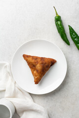 Overhead view of samosa on a white plate, top view of beef samosa on a white background