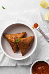Overhead view of samosa on a grey plate, top view of beef samosa on a marble countertop