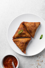 Overhead view of samosa on a white plate, top view of beef samosa on a white background