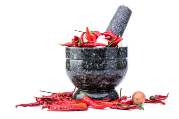 Black stone mortar and pestle, cooking utensil with fresh spicy red chili peppers, isolated on white background.