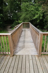 Natural park area with wooden boardwalk and bannisters vertical photo