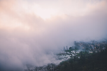 Panoramic image of the dense fog uncovering the rice terraces in Duoyishu, China