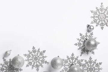 Frame made of decorative snowflakes and Christmas balls on white background, closeup