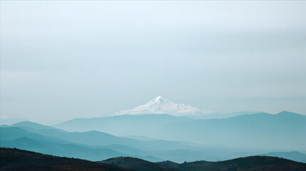 Sunrise paints a beautiful reflection of Mount Fuji's snowy peak on the calm lake, as the morning fog softly blankets the surrounding landscape