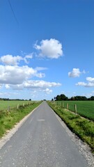 Fototapeta premium Empty Rural Road Under Blue Sky