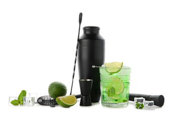 Glass of fresh cocktail with lime and bartender tools isolated on white background