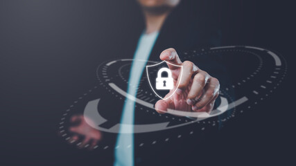 Businessman touching glowing security shield lock icon, symbolizing cybersecurity, data protection, privacy, secure access, encryption technology, online safety and digital information security.