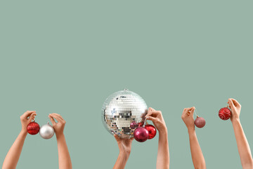 Female hands with disco ball and Christmas balls on green background