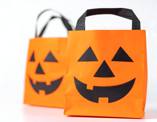 Two orange halloween treat bags with jackolantern face isolated on white background