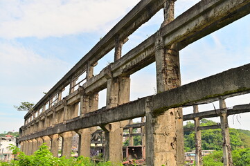 Documentary architectural photography of deteriorating Agenna Shipyard concrete ruins showcasing industrial decay beauty and maritime heritage landmark in Keelung harbor.