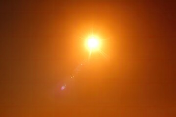Intense sun, lens flare on orange sky