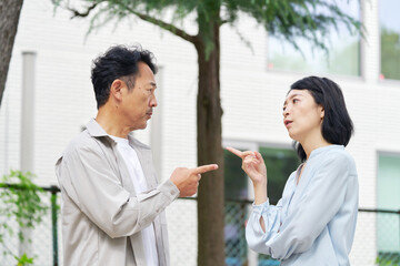 夫婦喧嘩する中年の夫婦　屋外
