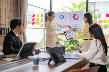 Businesswomen exchanging documents with charts during office presentation