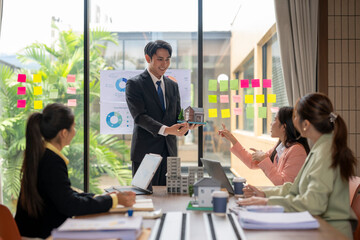 Real estate agent showing house model to investors during meeting