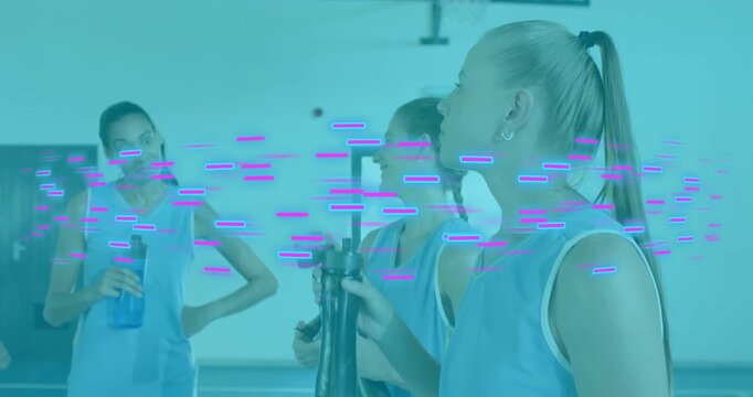 women basketball teammates hydrating with water bottles during sports timeout on court, bonding