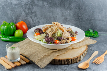 Crispy Chicken Skin Salad served with fresh vegetables and creamy dressing – a fusion of crunch and freshness