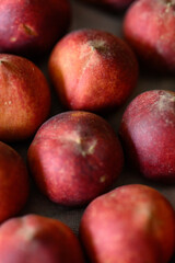 Beautiful tasty fresh peaches laying out on a table with bright red, orange and peach colors.