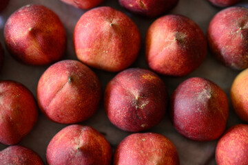 Beautiful tasty fresh peaches laying out on a table with bright red, orange and peach colors.