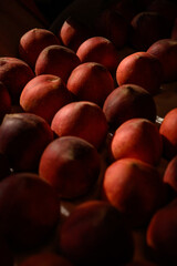 Beautiful tasty fresh peaches laying out on a table with bright red, orange and peach colors.