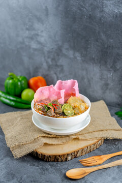 Soto Padang is a classic Minang beef soup with clear broth, fried crunchy beef, vermicelli, potato croquette, and pink sago crackers. Its rich spices and fresh toppings create a flavorful, vibrant bow