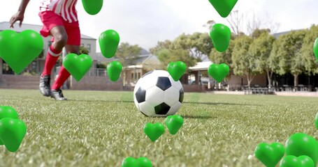 Male athlete approaching soccer ball and showing trapping dribbling with floating hearts for sports - Powered by Adobe
