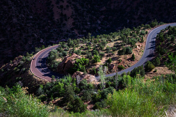 Scenic highway hairpin turn on a sunny summer day in a arid desert southwest environment, motorcycle and rider travelling from Zion National Park, Utah
