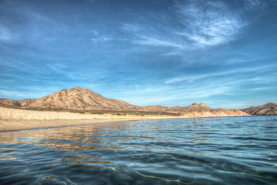 Desert and sea in La Paz Baja California Sur Mexico, seascape with crystal clear water mountains in the background and sunny blue sky horizontal sea of cortes