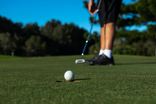 A golfer putting for the hole - horizontal
