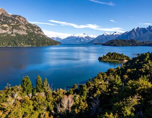 Panoramic view of a serene lake nestled amidst snow-capped mountains
