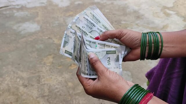 Indian female counting 500 rupees Indian currency notes	