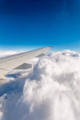 Obraz premium View from the airplane window at a beautiful cloudy sky and the airplane wing