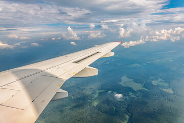 Obraz premium View from the airplane window at a beautiful cloudy sky and the airplane wing