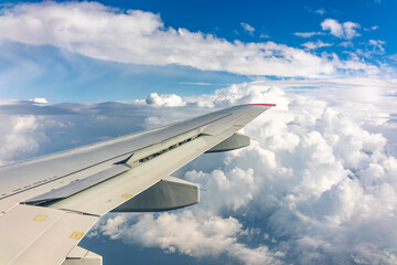 View from the airplane window at a beautiful cloudy sky and the airplane wing