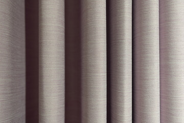 Fototapeta premium Modern Gray Curtain with Pleats. hanging in soft, elegant vertical pleats. a sophisticated and modern feel. The gentle lighting highlights the graceful folds and shadows, creating a sense of depth.