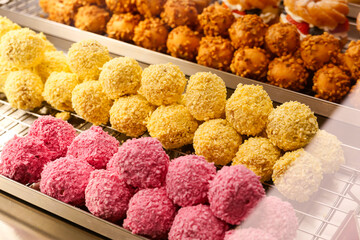 Colorful Assorted Sweet Dessert Balls in Bakery Display. variety of sweet treats, vibrant colors, and delicious textures, perfect for themes of confectionery, dessert shop, and food photography.