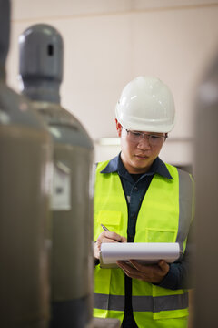 Engineer inspecting SF6 gas cylinders in industrial facility. Focus on safety, pressure container inspection, hazardous material management, and workplace safety checklist documentation
