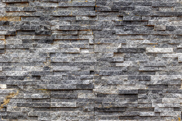 Textured stone brick wall with grey and beige tones surface background
