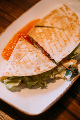 Flatbread grilled. Salad pita. Portion wheat vegetable wrap food served on plate. Roasted tasty meal with tomato pepper sauce dish.