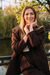Female portrait. Carefree weekend. Cheerful happy confident woman posing in sunlight in spring park.