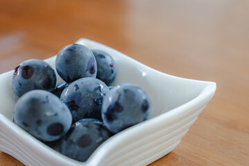 Fresh Kyoho grapes in a white bowl
