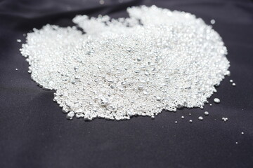 A pile of sparkling pure silver grains, refined to 99.99% perfection, sparkle under the light. Each tiny grain reflects clarity and value.